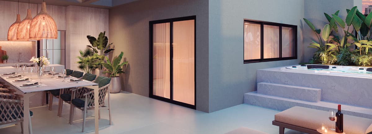 Varanda com mesa posta, sauna envidraçada e spa elevado cercado de plantas